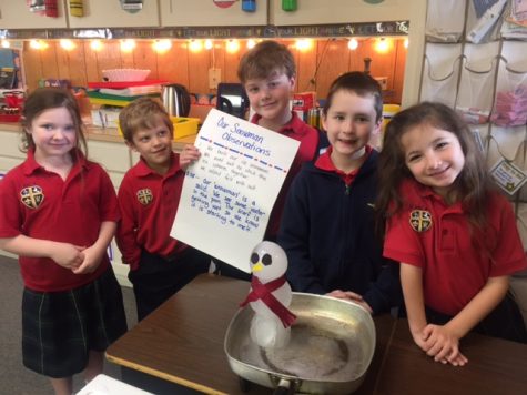 First grade students stand with their