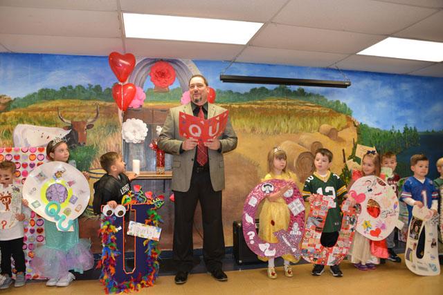 The Pre-K students stand dressed as queens and quarterbacks during the wedding. 