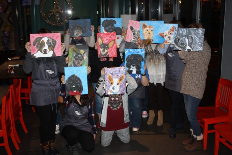 The painters show off their finished paintings of their furry friends