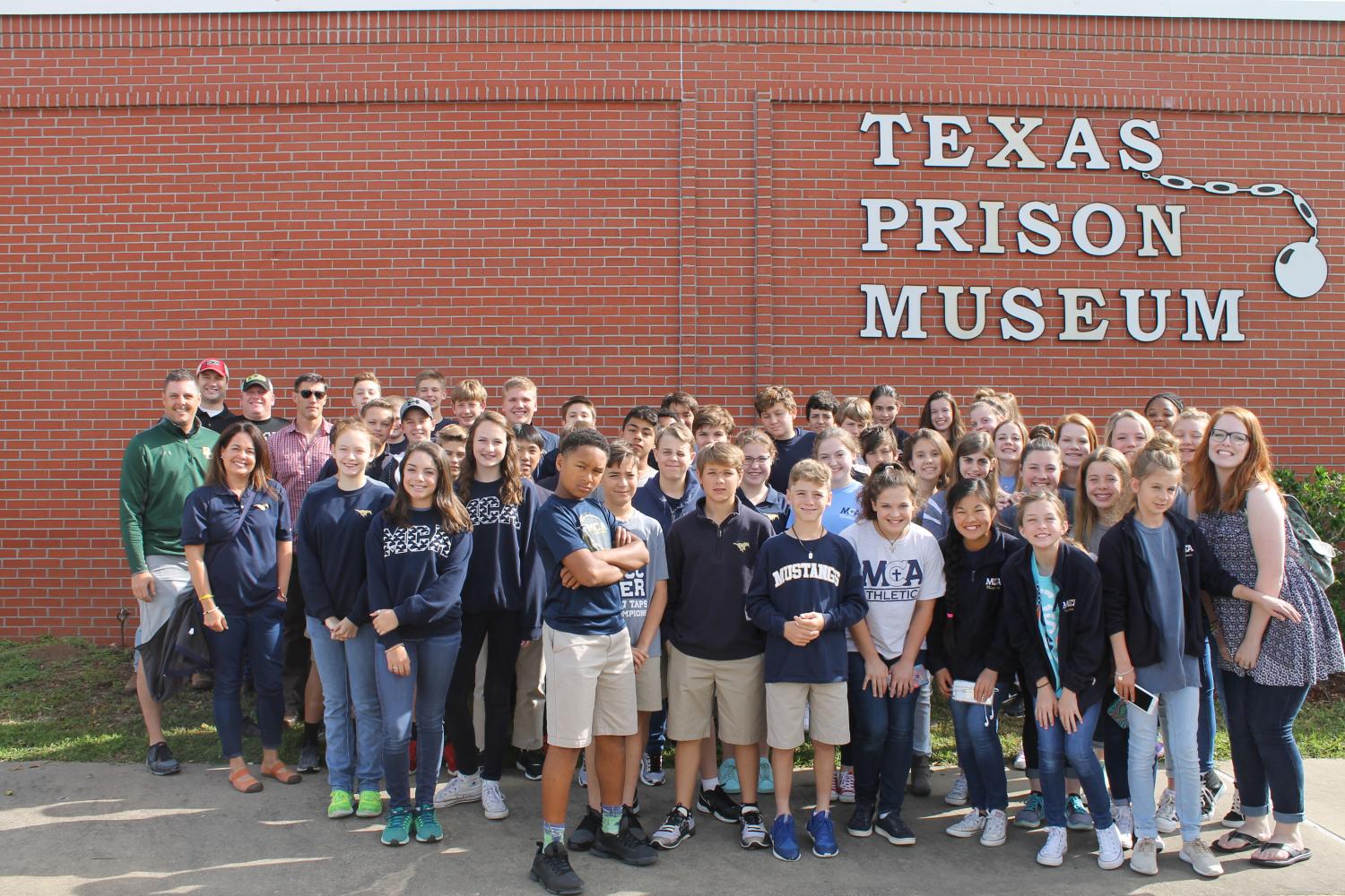 The seventh graders and mca chaperons strike a serious pose in front of the Texas Prison Museum.
