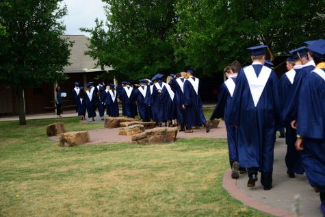 The Seniors walk down the main path of the courtyard towards the Lower and Middle School deck.