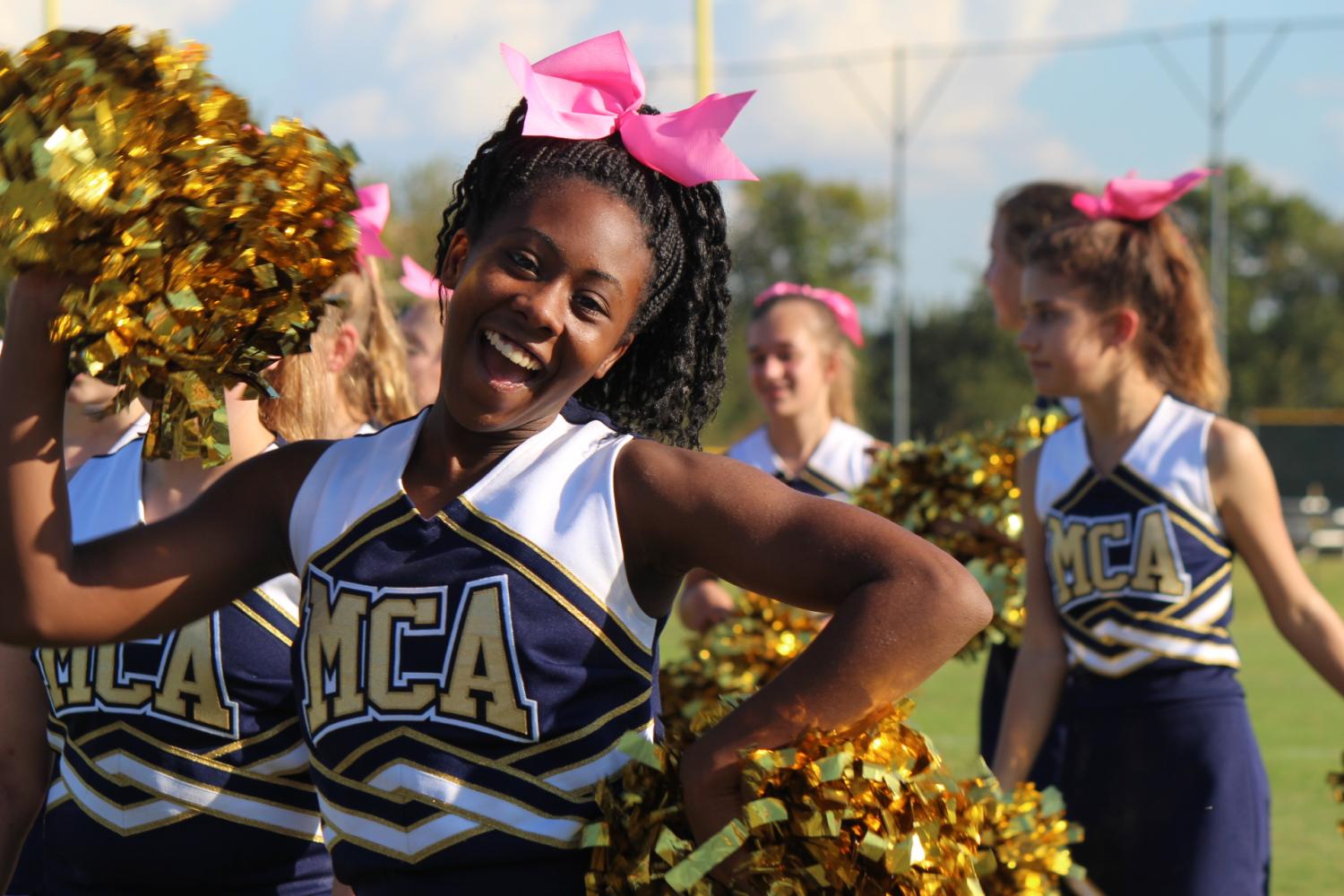 Morgan McGee waves her pom poms in the air. 