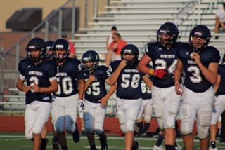 Some of the MCA football starters head out to the field ready to play.