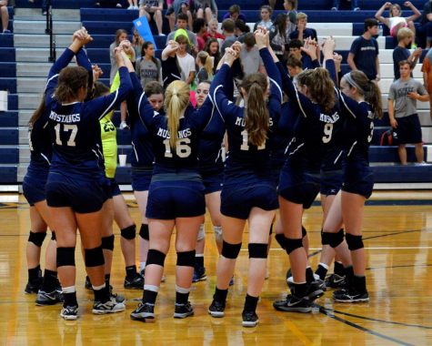 The Varisty girls pray before their third district game of the season.