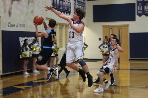 Will Baxter, junior, blocks a shot by Coram Deo guard.