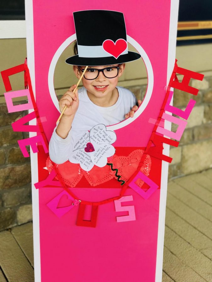 First grade students take Valentines Day pictures in a crafty photo booth.