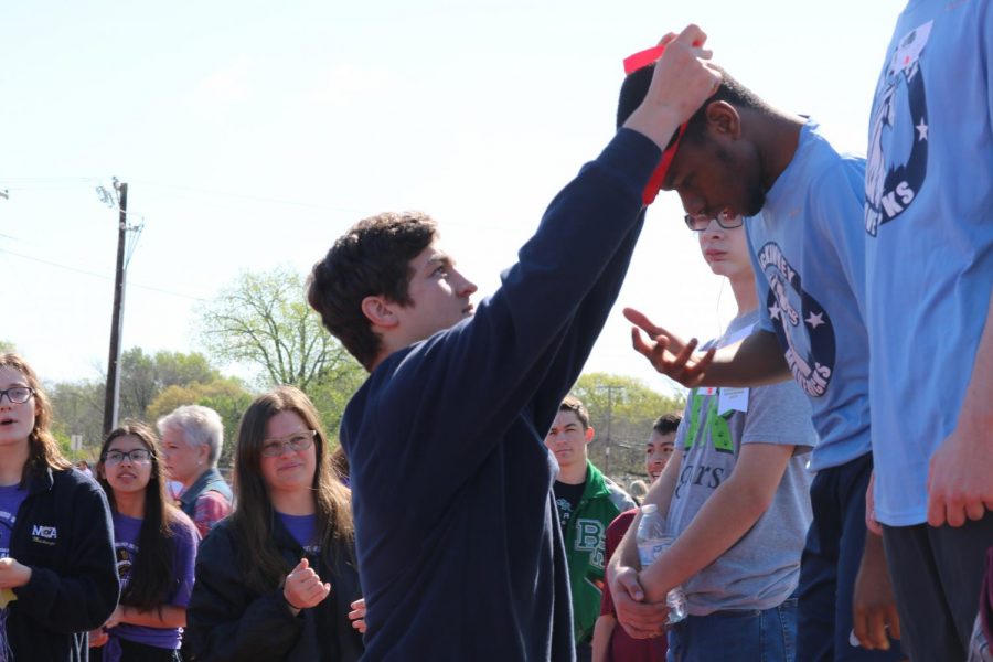 Junior Caleb Doyle awards one of the participants a medal after the event. 