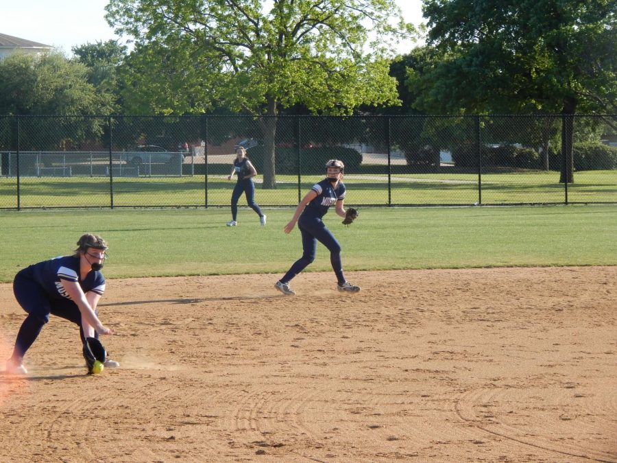 Third baseman Allie Smith fields the ball and throws the runner out at first. 