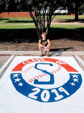 Senior Sam Utzig takes a picture after finishing painting his parking spot.