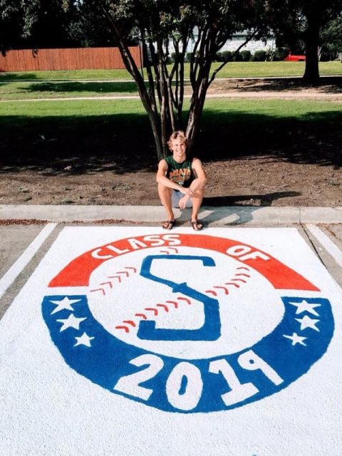Senior Sam Utzig takes a picture after finishing painting his parking spot. 