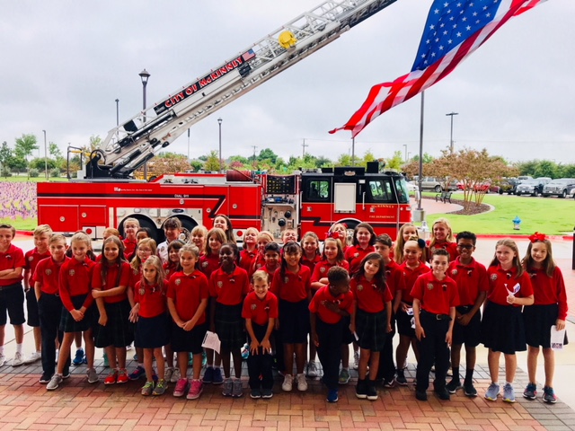 The+Lower+School+Honor+Choir+groups+together+to+take+a+picture+in+front+of+the+fire+truck.