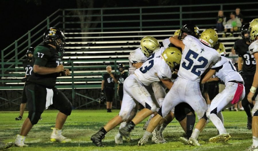 Senior Captain Caleb Doyle  leads a group of Mustangs in a tackle.