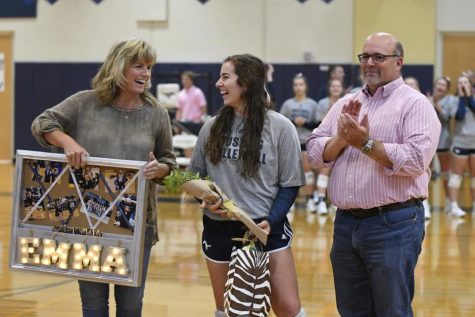 Senior Emma Lowes laughs with her family as she is recognized at senior night.