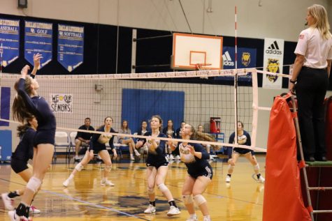 Sophomore AvaGrace Haggard and junior Allie Smith get ready to block Prince of Peace hitter in the fourth set.