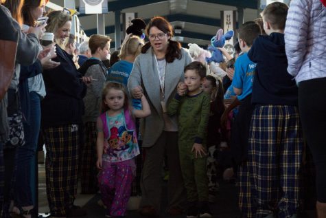 A lower school mom marches her kids to their first period classes so they can get ready for the parade with their classes.