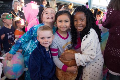 A group of kids smile for a picture together, in their favorite pajamas.