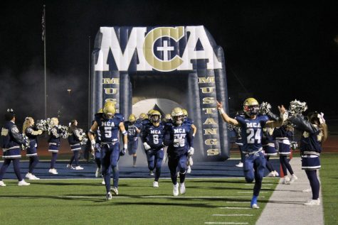 Mustangs run out of the tunnel to the fight song ready to play. 