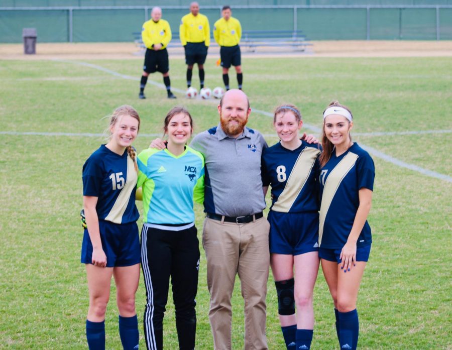 Seniors, Kate Witte, Elyse Mead, Juliana Roller and Emma Thompson pose for a picture with head coach, Tyler Ferguson, after being showcased.  