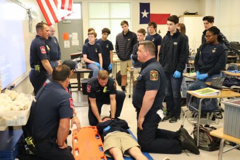 The class is taught by Station 2 on how to gently place an injured person onto a backboard.