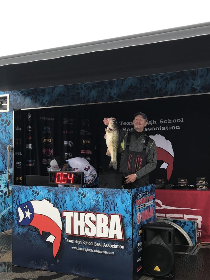 Boat Captain Jon David Cross holds up his winning fish, as the crowd cheers in excitement.