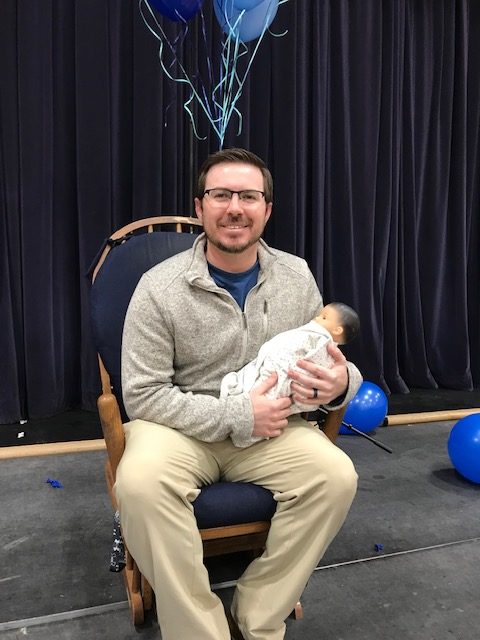 Middle school teacher and coach Brady James gets surprised last week at the middle school chapel.  They showered him with baby gifts and fun games. 
