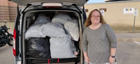 Kristin Urban stands beside some of the 400 pounds of clothing that were donated from MCA.