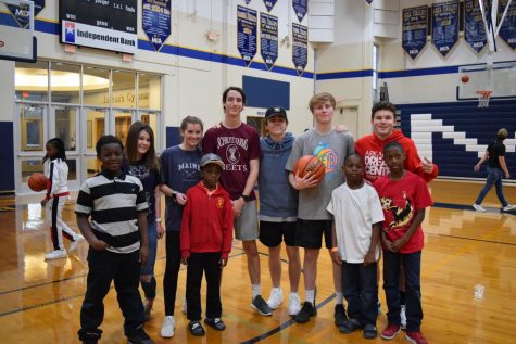 Seniors, Lauren Shackelford, Juliana Roller,Mason Lee, Trey Faulkner, Kade Stephens, and Dylan King pause a basketball game to take a picture with kids from the Dream Center.