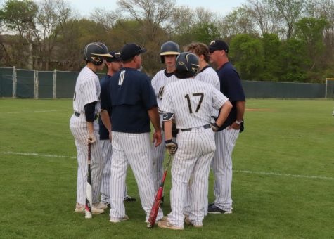 Head coach Mike Pirtle talking to the baserunners while the other team changes pitchers.