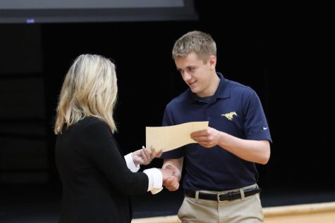 Christian Simonsen shakes Mrs. Smith's hand as he accepts his NHS certificate.