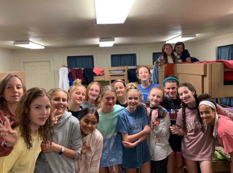 A group of 7th grade girls take a picture while hanging out in the cabin.