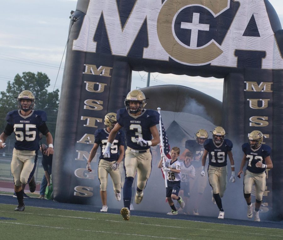 The Mustangs running out of the tunnel as they take on Temple Christian