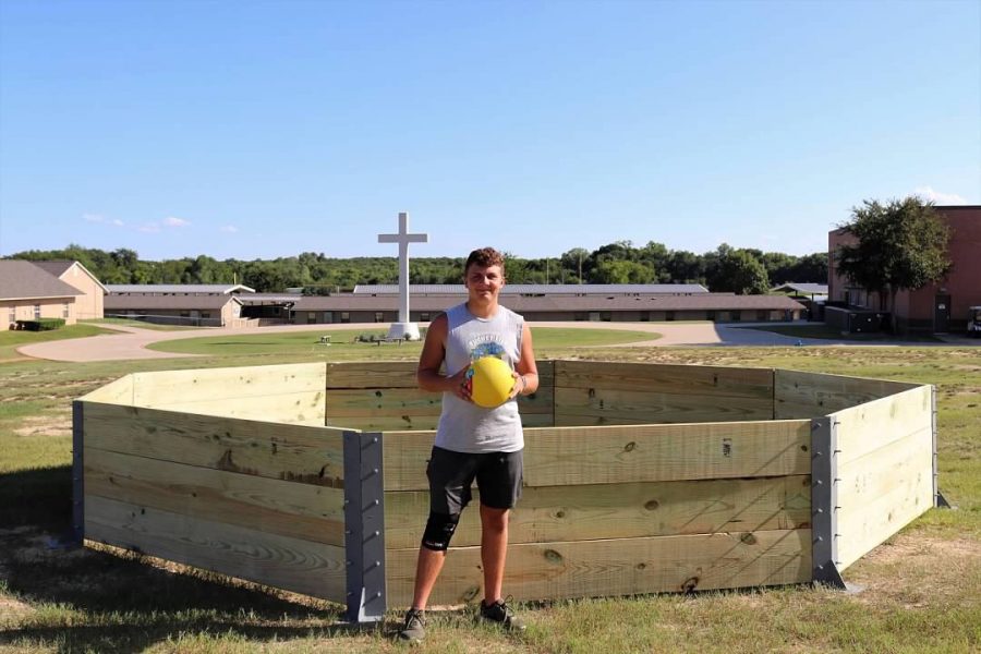 Senior, Will Boese poses in front of his gaga pit after a long day of building it.