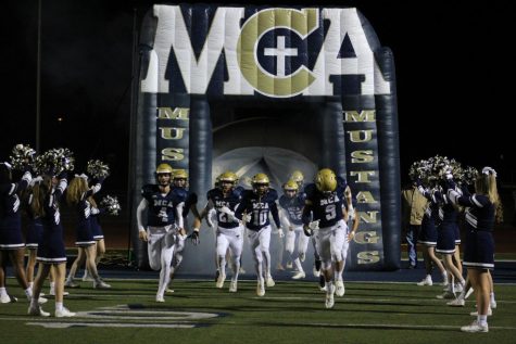 The Mustang football team runs out of the tunnel for the last home game of the season.