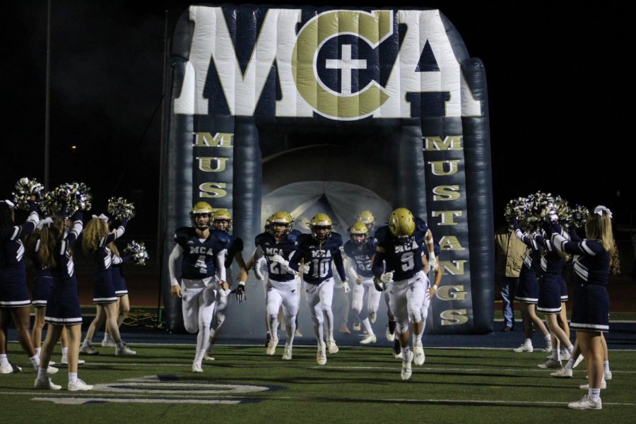 The Mustang football team runs out of the tunnel for the last home game of the season. 