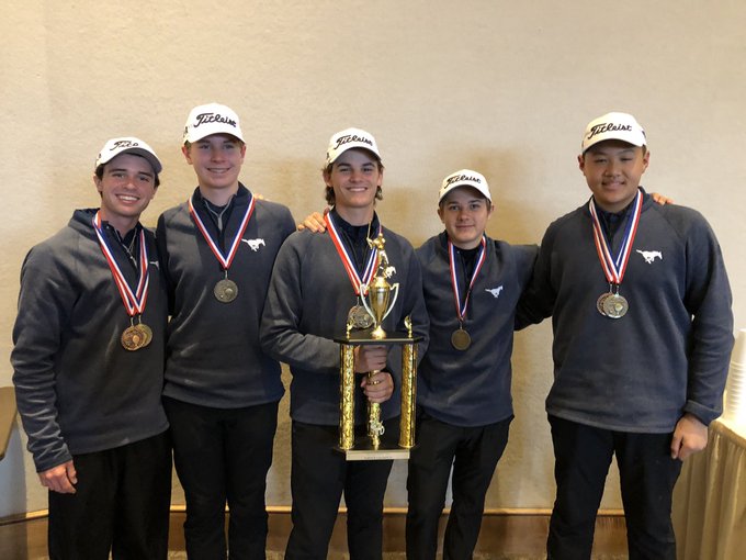 The varsity boys pose with their trophy after a cold round of golf.