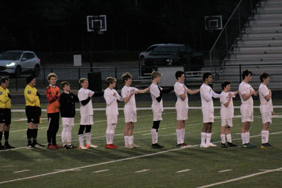 Mustang varsity boy soccer team stands as the national anthem plays.