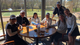 Varsity girls golf team and coaches pose for a photo after their tournament. 