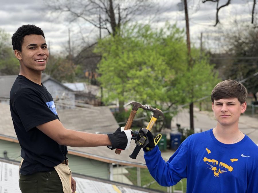 Juniors John DeLatte and  Asa Miller pose for a picture before going back to removing nails from the roof. 