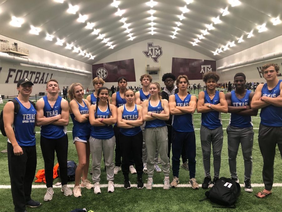 At Texas a&m for a meet, the Texas Speed Project pose for a picture in a&ms indoor training facility.