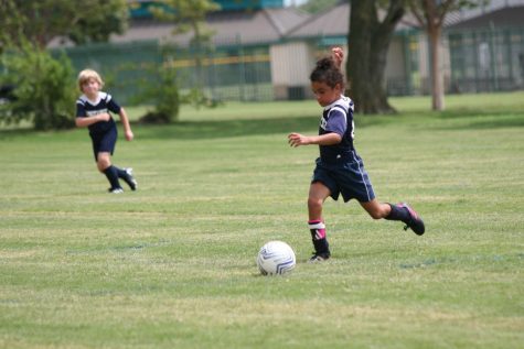 First grader Judah Lewis takes a big step preparing to kick the ball.