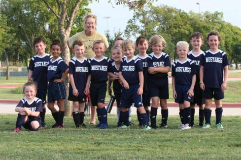 After their game, the first grade Lil Stangs  take a group picture with first grade teacher Elise McKeller.