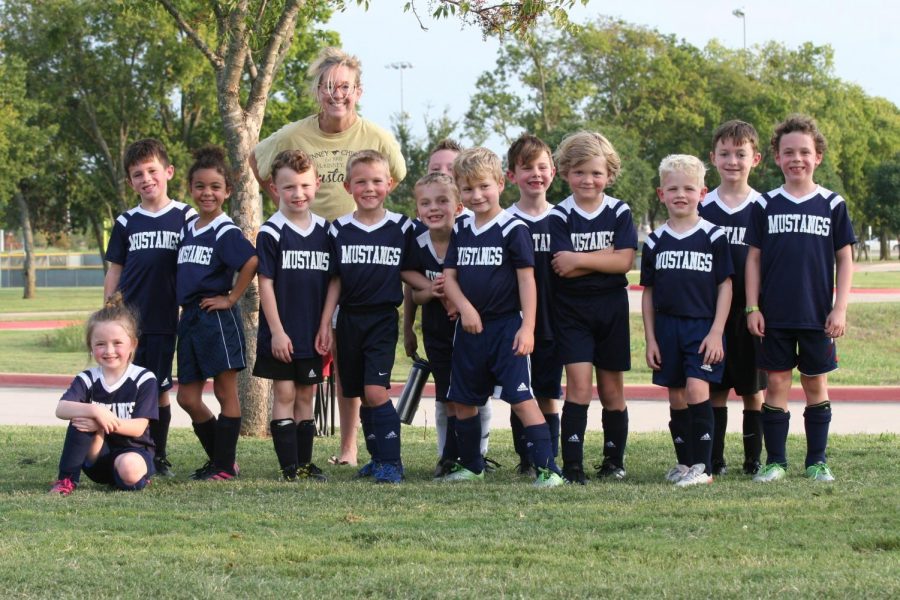 After their game, the first grade Lil Stangs  take a group picture with first grade teacher Elise McKeller.