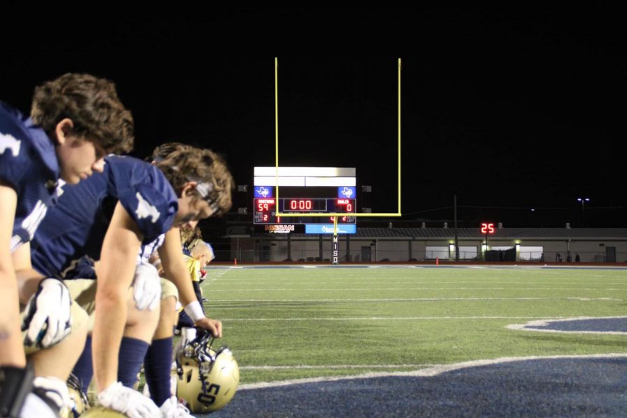 The+team+kneels+to+pray+by+the+scoreboard+after+the+game.+