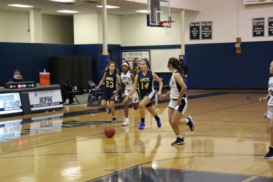 Eighth grader, Casey Gerardis dribbles the ball up the court.