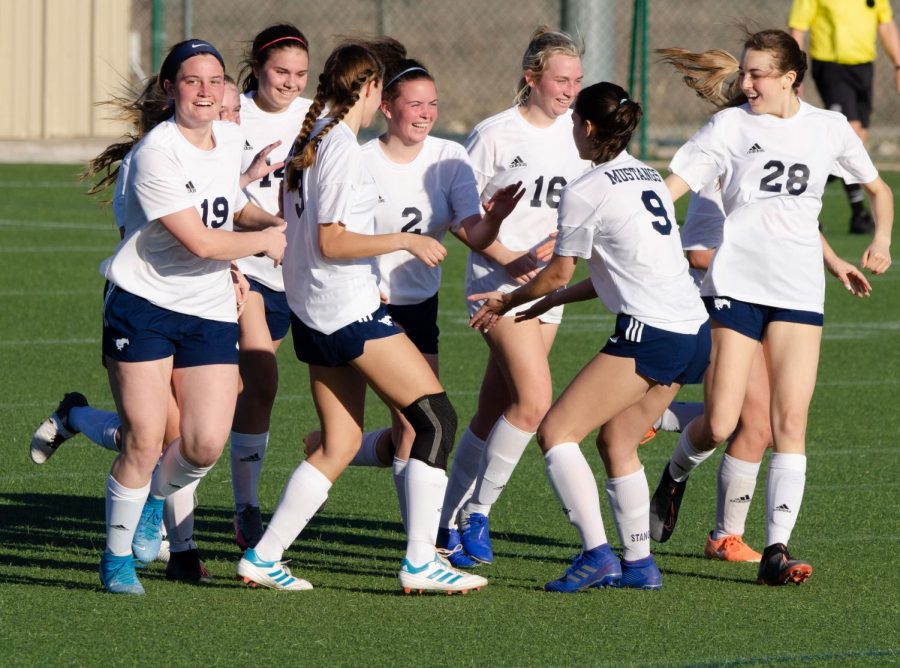 The team congratulates senior Micah McDowell for her goal.