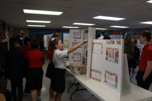 Fifth graders Megan Moates and Isabella Melton look at their friends project.