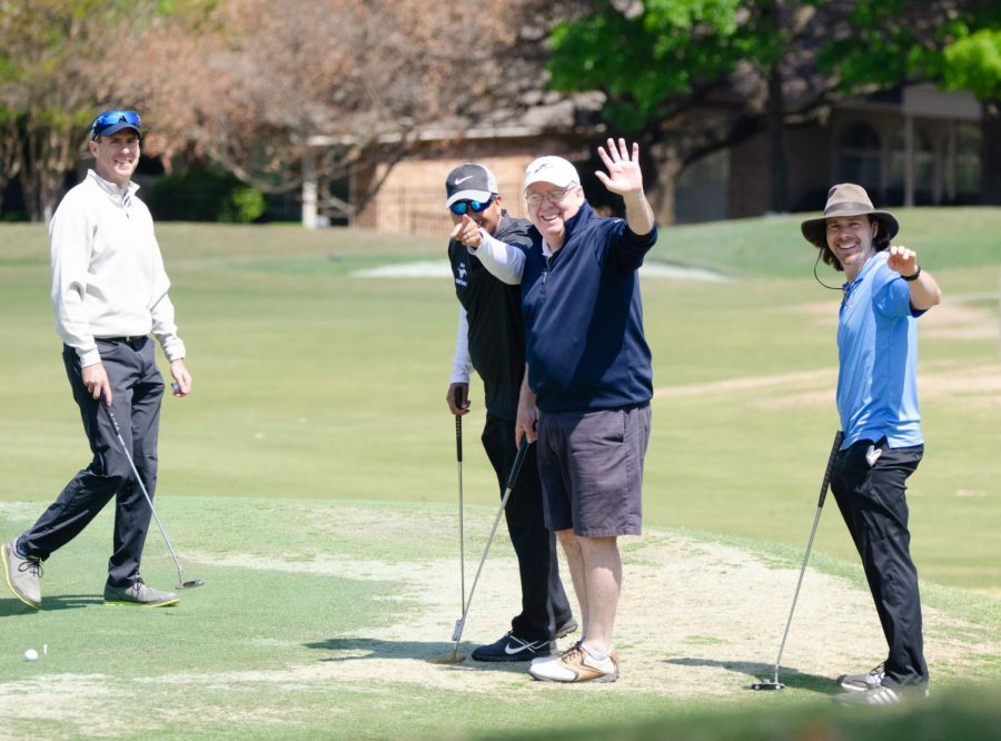 Golfers waving at the golf tournament. 