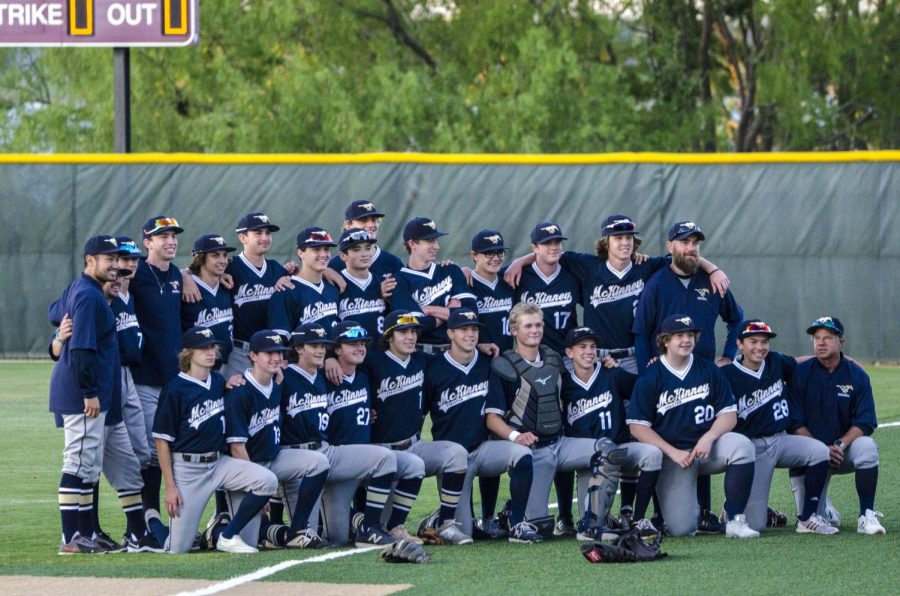 The baseball team takes a group photo after the win.