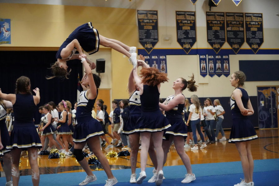 Varsity+Cheer+performs+a+stunt+during+the+pep+rally+on+Thursday.+
