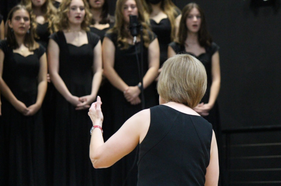 Choir teacher Amy Jordan leads students through song.